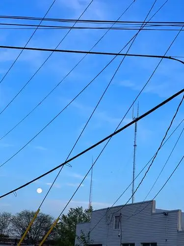 Urban ballet of wires under a moonlit sky.